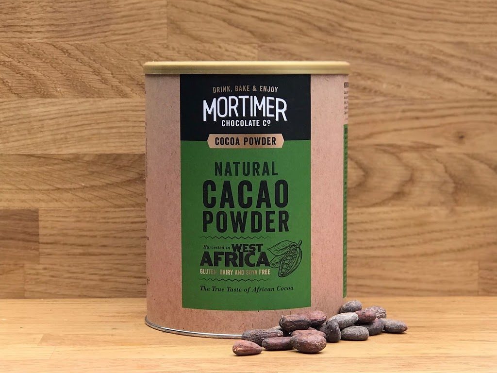 a lifestyle image of natural cacao powder with cocoa beans beside the product