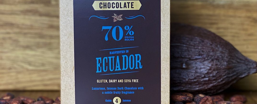 70% Ecuador Chocolate Powder as a lifestyle image with a cocoa pod and cocoa beans