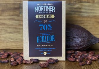 70% Ecuador Chocolate Powder as a lifestyle image with a cocoa pod and cocoa beans