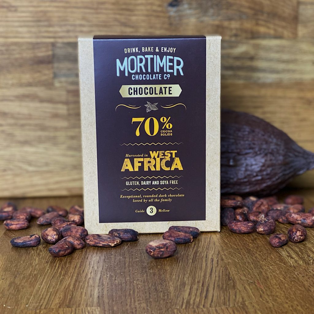70% West African Chocolate Powder as a lifestyle image surrounded by cocoa beans and a cocoa pod