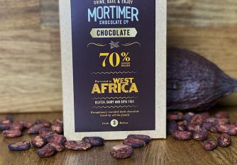 70% West African Chocolate Powder as a lifestyle image surrounded by cocoa beans and a cocoa pod