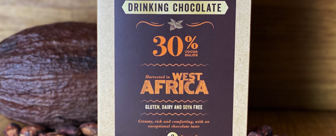30% West African Drinking Chocolate as a lifestyle image surrounded by a cocoa pod and cocoa beans