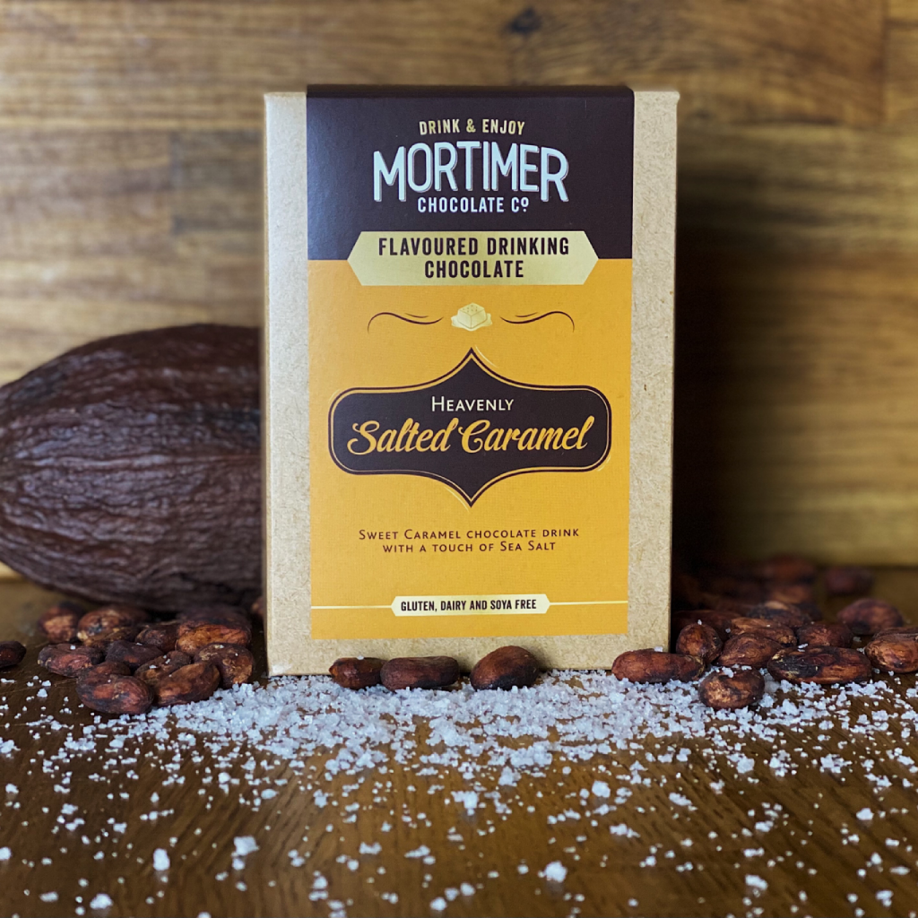 Salted Caramel Drinking Chocolate as a lifestyle image surrounded by salt, cocoa pods and cocoa beans