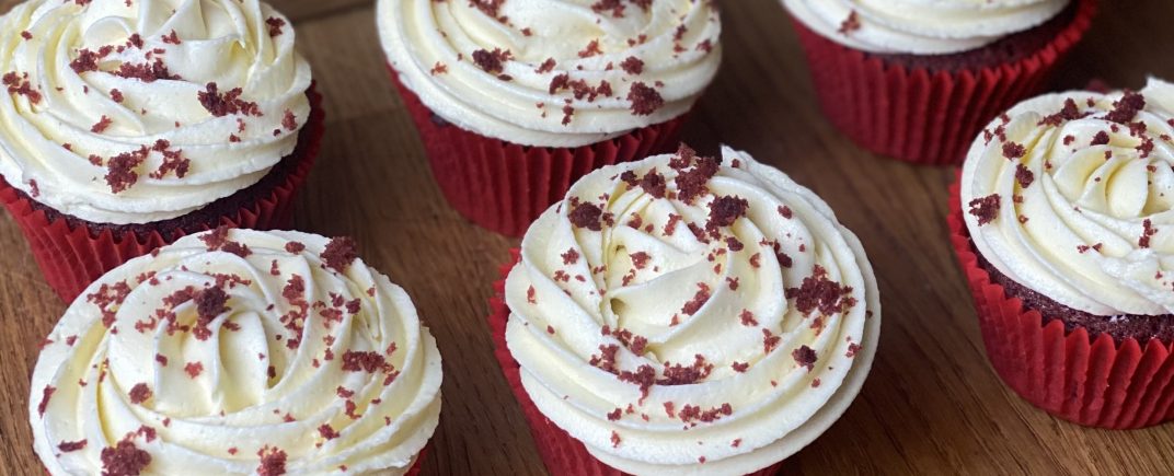 Red Velvet Cupcakes with cream cheese frosting and red velvet cake crumbs sprinkled on top