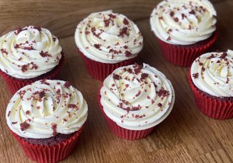 Red Velvet Cupcakes with cream cheese frosting and red velvet cake crumbs sprinkled on top